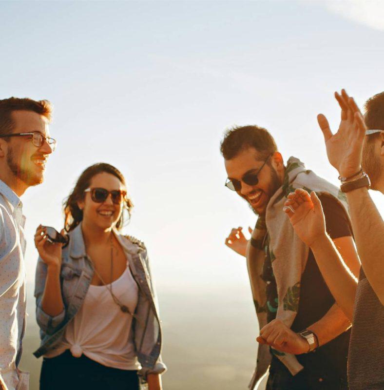 four adults outside smiling
