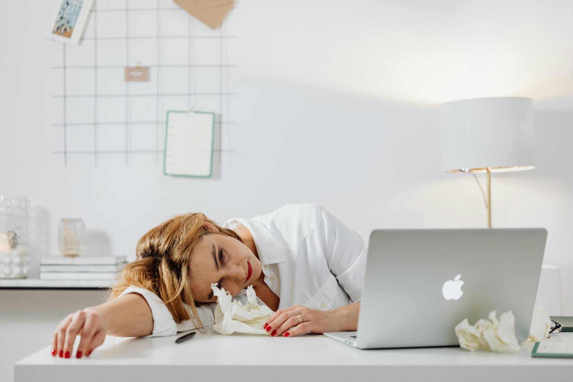 a stressed-looking woman sitting in front of a laptop computer