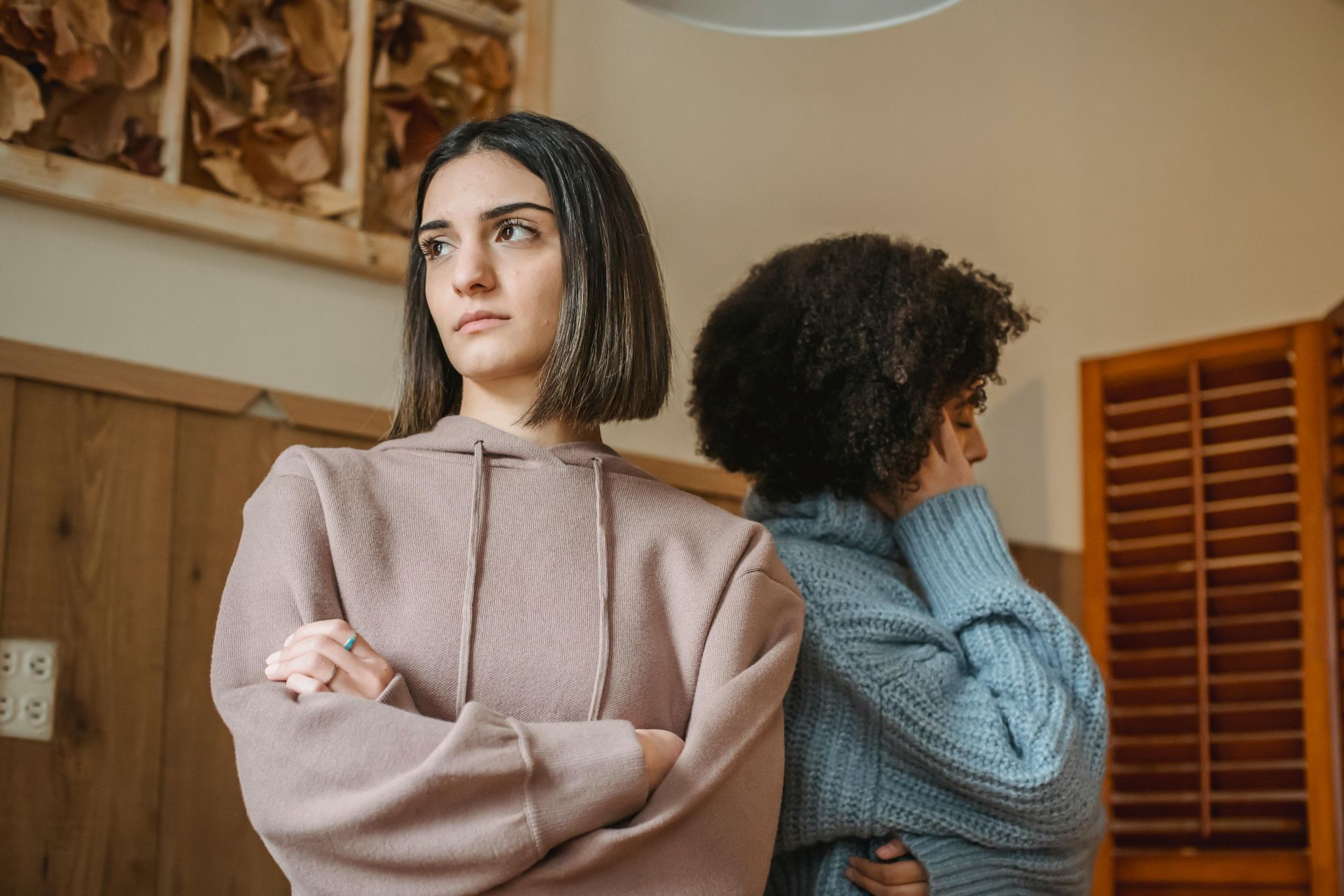 two women standing next to each other in a room