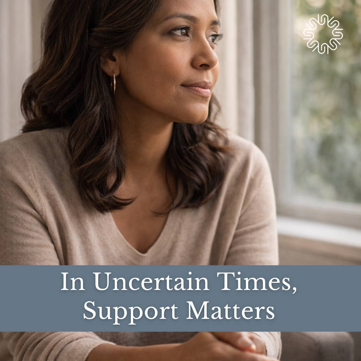 a woman looking out a window with the words in uncertain times, support matters