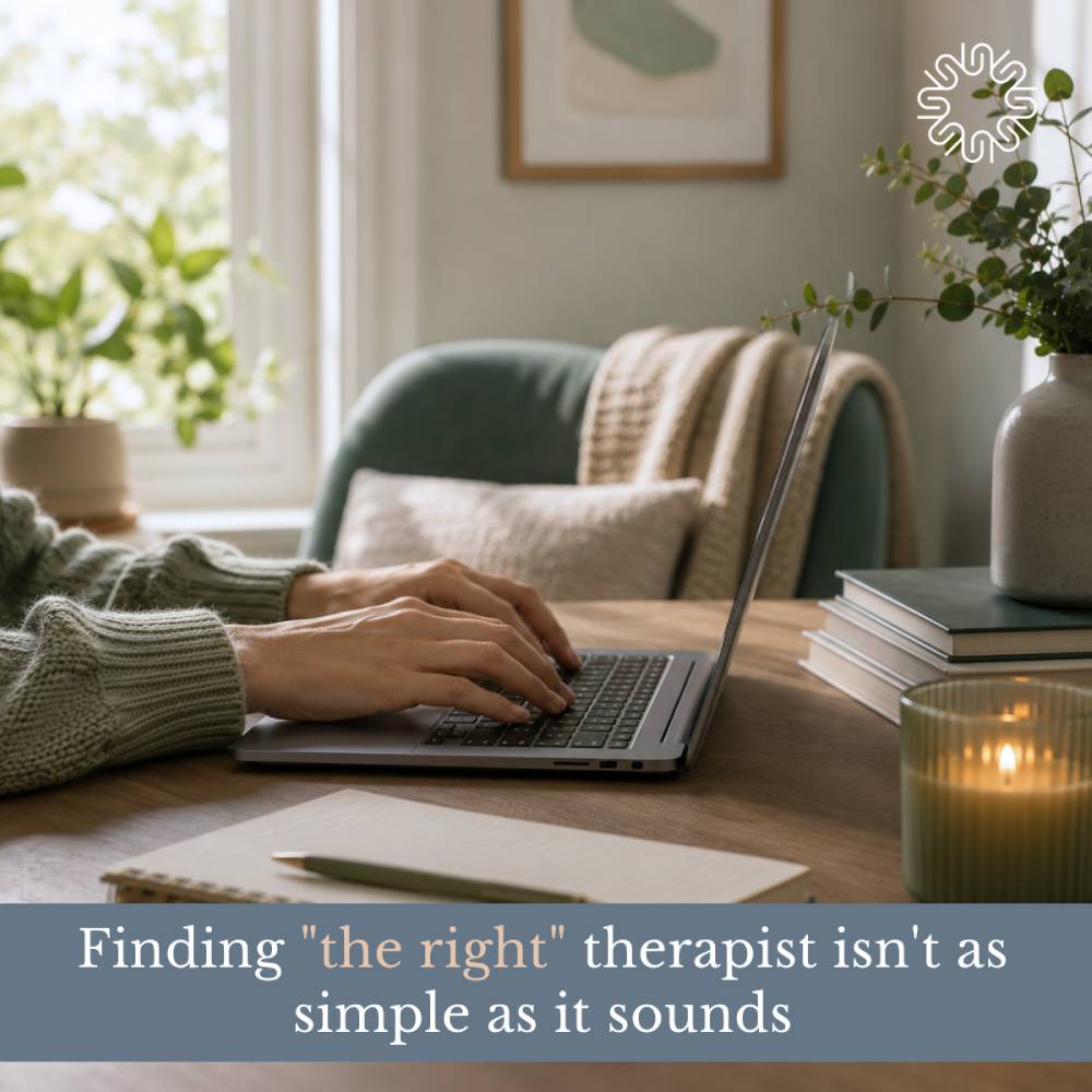 Person using a laptop at a wooden table with a notebook, pen, and lit candle, featuring text overlay that reads "Finding 'the right' therapist isn't as simple as it sounds".